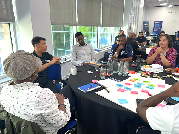 Black Leaders in Sports at a table with a post-its working together